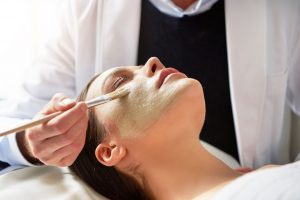 cosmetologist-putting-mask-on-female-face-with-8GWXHFP.jpg